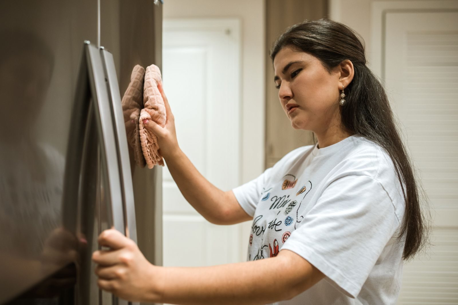 Cleaner wiping a refrigerator door